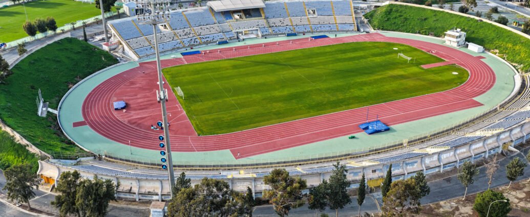 Aerial view of GSZ Stadium in Larnaca, Cyprus showing football field and athletics track.