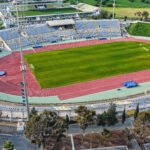 Aerial view of GSZ Stadium in Larnaca, Cyprus showing football field and athletics track.