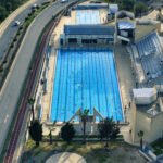 Aerial view of the Olympic swimming pool in Larnaca, Cyprus with 50 meter lanes and spectator stands.